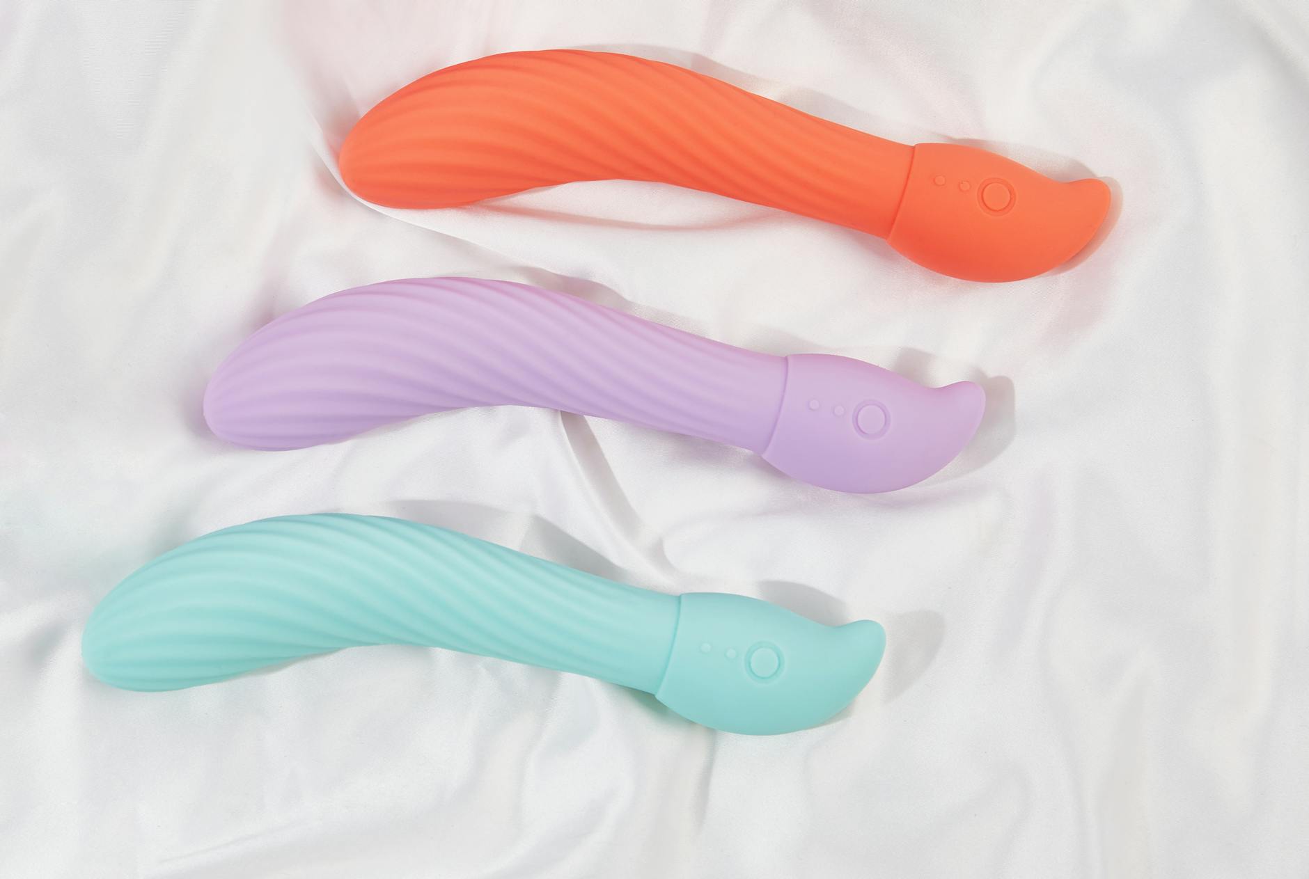 Una mano sosteniendo un vibrador de limón contra un fondo morado minimalista, mostrando sensualidad moderna.