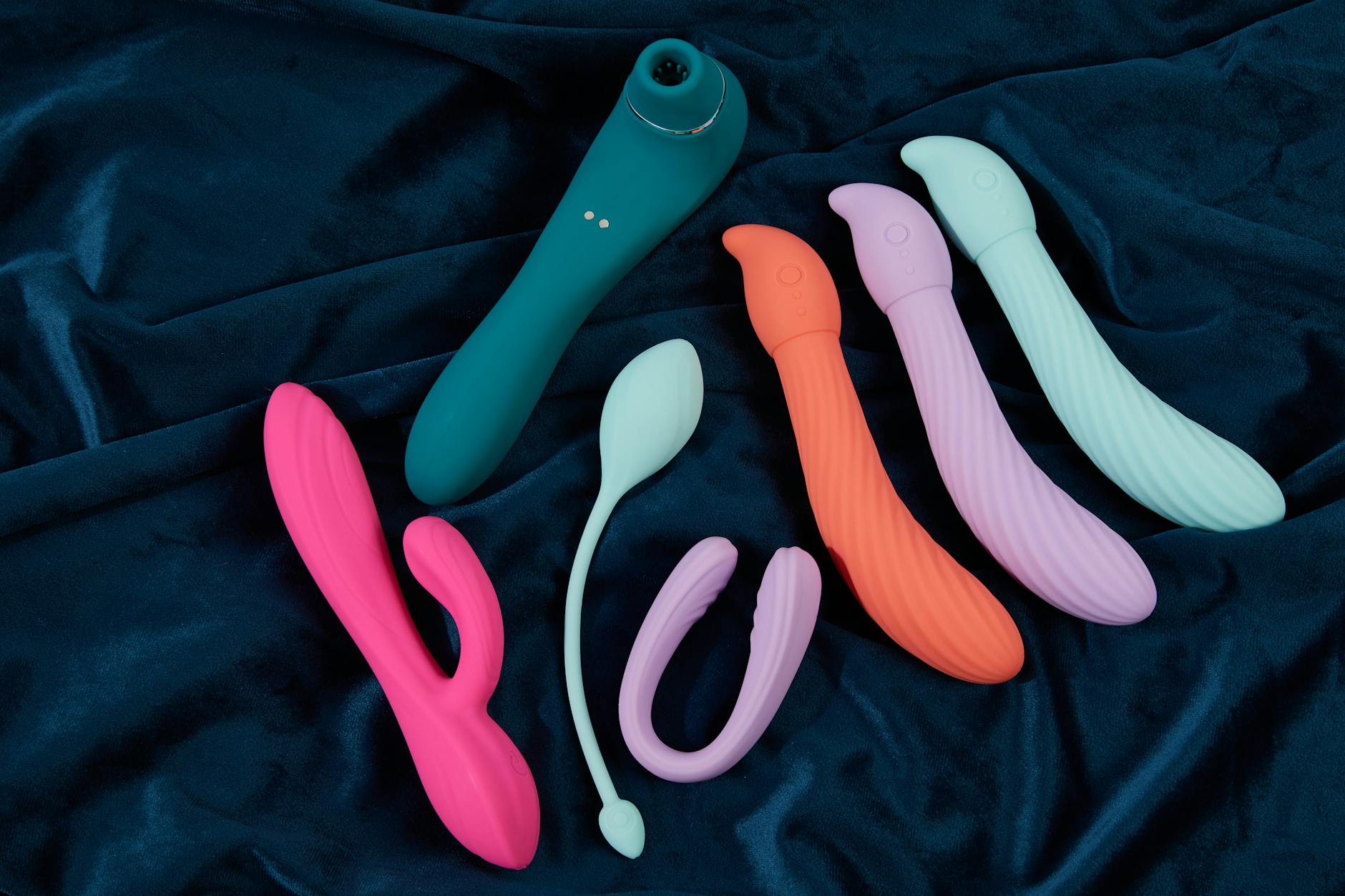 A hand holding a vibrator against a minimalistic backdrop, representing a fresh start with pleasure
