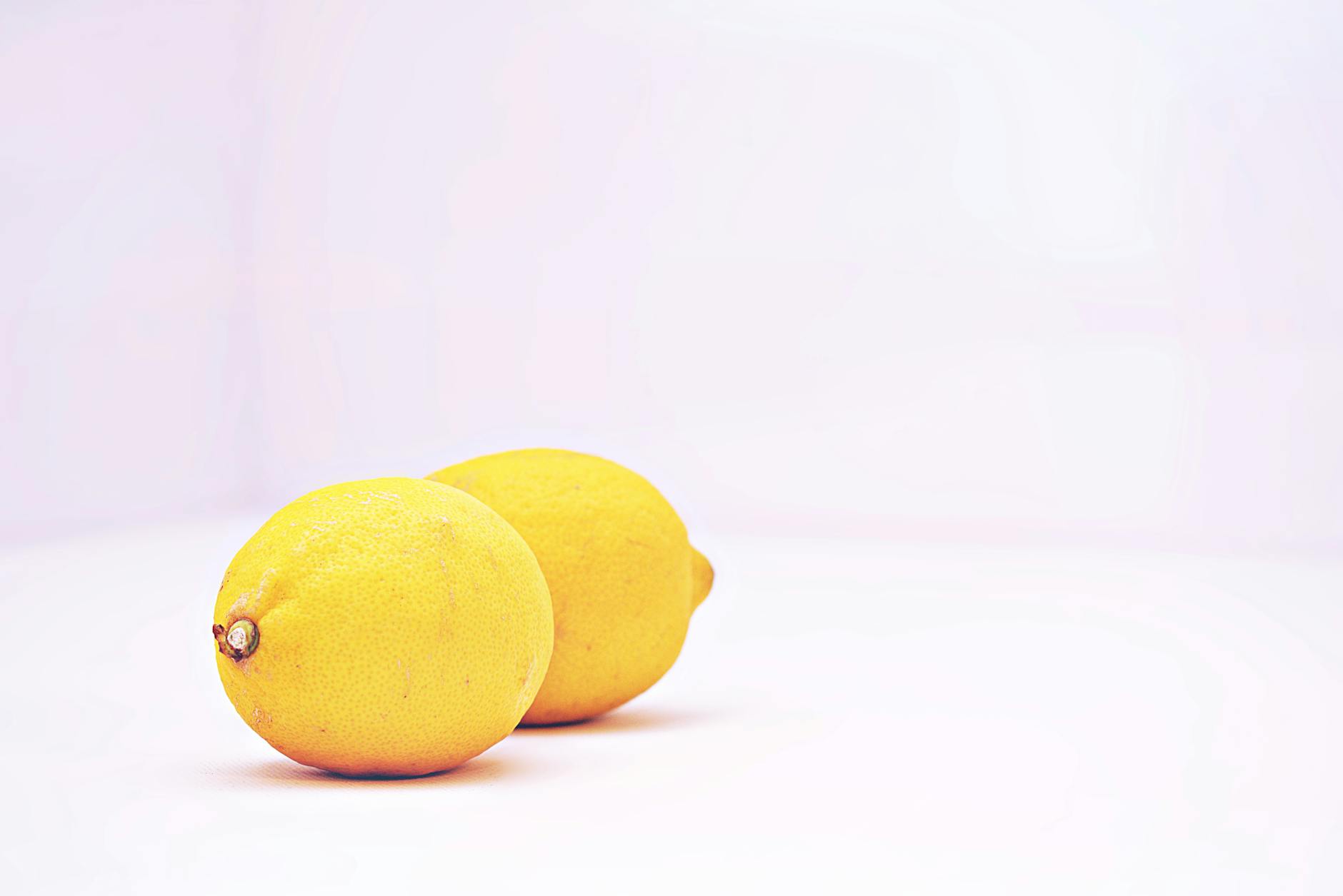 Two vibrant fresh lemons on a white background symbolizing renewed vitality and reconnection