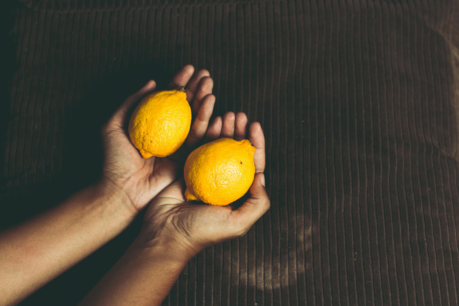 Fresh lemons held in cupped hands, symbolizing care and intentionality
